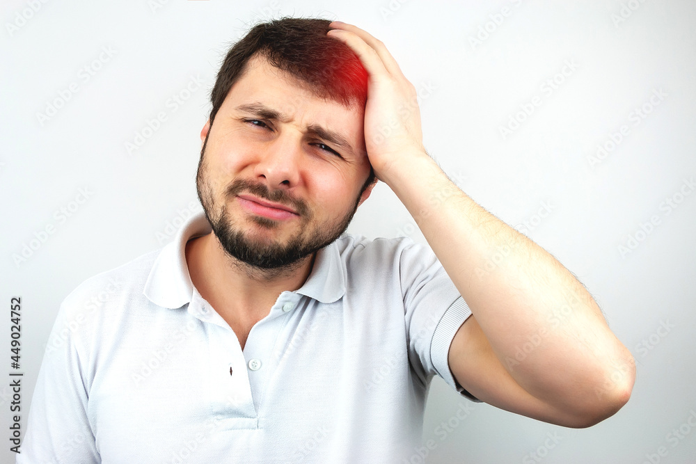 Handsome bearded man holding his head with his hand and suffering from headache or migraine on white background Handsome bearded man holding his head with his hand and suffering from headache or migraine on white background