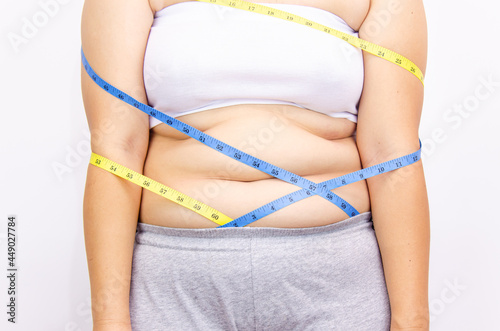 Beautiful fat woman with tape measure She uses her hand to squeeze the excess fat that is isolated on a white background. She wants to lose weight  the concept of surgery and break down fat under the