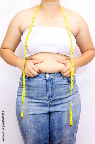 Beautiful fat woman with tape measure She uses her hand to squeeze the excess fat that is isolated on a white background. She wants to lose weight, the concept of surgery and break down fat under the