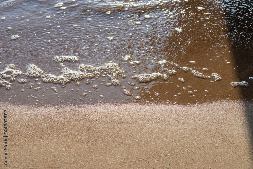 Soft wave of the sea on the sandy evening beach.Soft focus,blurred image. Soft wave of the sea on the sandy evening beach.Soft focus,blurred image.