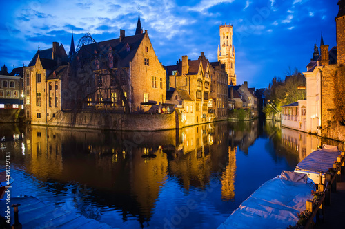 Romantic evening view of the canal, illuminated by old town lights and reflections in the water, Bruges, Belgium.