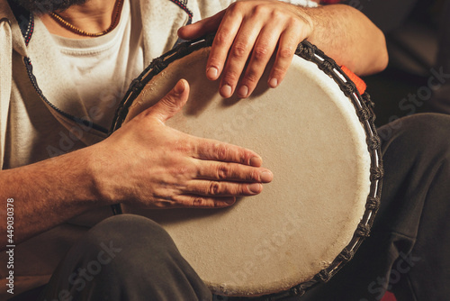 The drummer plays the ethnic percussion musical instrument djembe photo