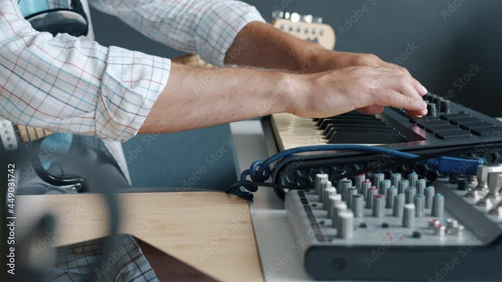 Close-up of guy's hands touching keyboard buttons adjusting musical instrument then playing indoors in studio. Creative people and music concept. Close-up of guy's hands touching keyboard buttons adjusting musical instrument then playing indoors in studio. Creative people and music concept.