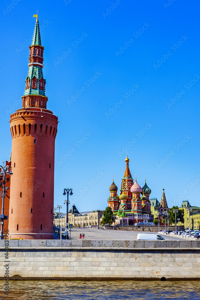 Fototapeta premium Beklemishevskaya Tower of the Moscow Kremlin, Vasilievsky Descent and St. Basil's Cathedral on a sunny summer day - Moscow, Russia, July 2021
