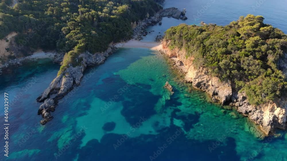 Panorama of beautiful coast of Corfu island at sunrise. Aerial view. Small beach surrounded by rocks covered with trees. Panorama of beautiful coast of Corfu island at sunrise. Aerial view. Small beach surrounded by rocks covered with trees.