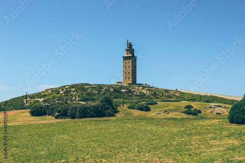 Old tower Hercules lighthouse over green field in A Coruña  © Radu