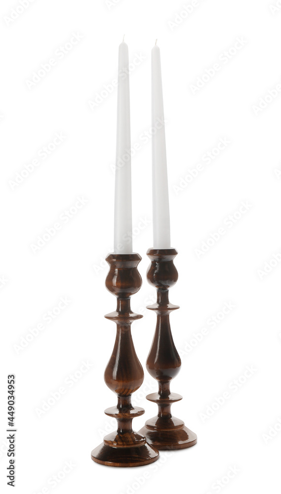 Elegant candlesticks with candles on white background