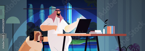 overworked arab businessman freelancer looking at laptop screen man sitting at workplace in dark night home room