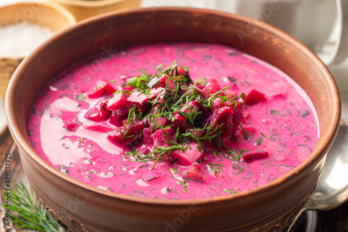 Cold borscht or Holodnik, traditional summer beet soup in ceramic bowl on wooden background photo