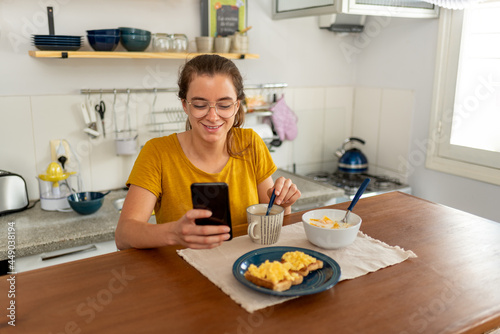 Young latin woman eating healthy breakfast with fruits at home.