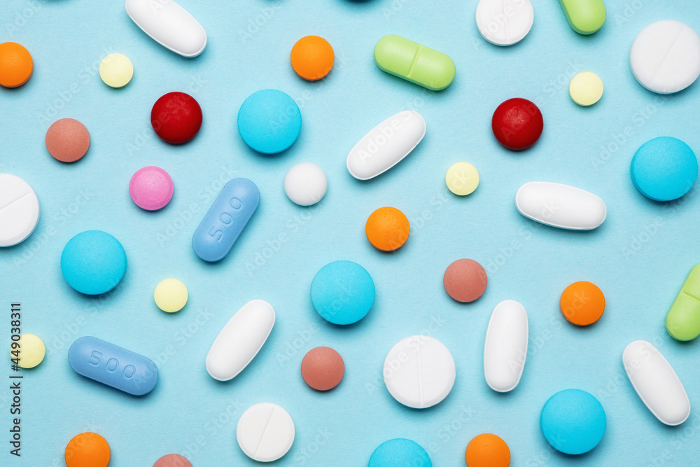 Medical drugs, tablets and pills on blue background. Background of different colorful pills and capsules. Medicine and treatment concept. Medical drugs, tablets and pills on blue background. Background of different colorful pills and capsules. Medicine and treatment concept.