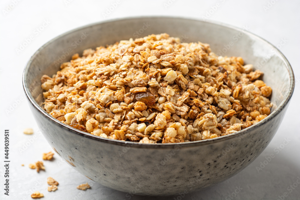 Granola cereal in bowl on concrete background Granola cereal in bowl on concrete background