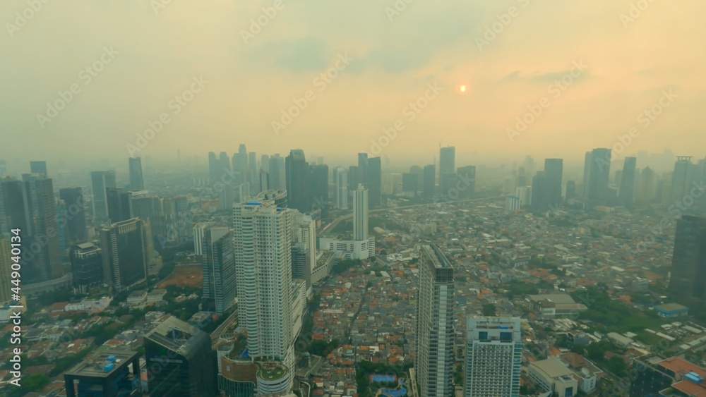 Time lapse city sunset through the glass. A beautiful urban panoramic cityscape from golden hour dusk to blue hour twilight. Sun setting and colours changing in the city centre of Jakarta, Indonesia.