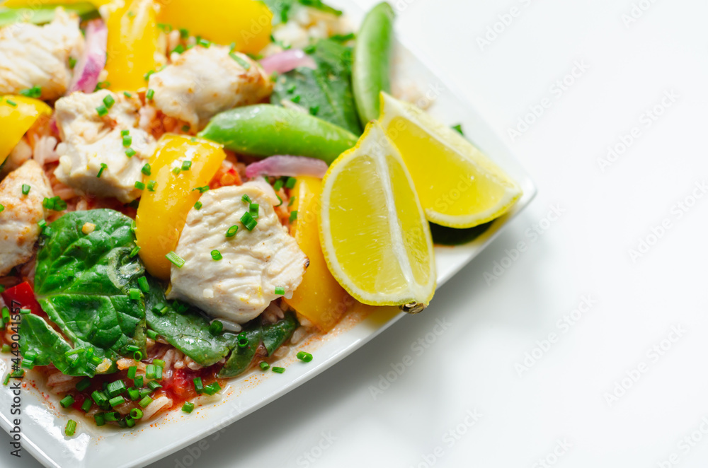 Cooked chicken breast pieces with peppers, sugar snap peas, and baby leaf spinach in a spicy sweet and sour sauce with fragrant rice Cooked chicken breast pieces with peppers, sugar snap peas, and baby leaf spinach in a spicy sweet and sour sauce with fragrant rice