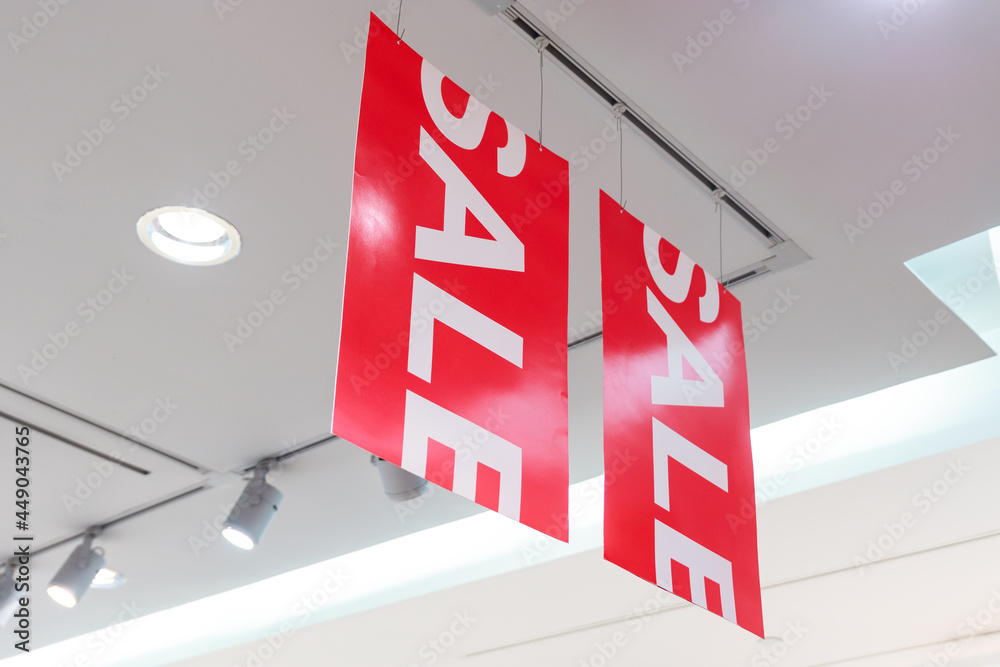 Φωτογραφία Big red sale sign in Clothes shop during the long holiday with spotlight to illuminate the store