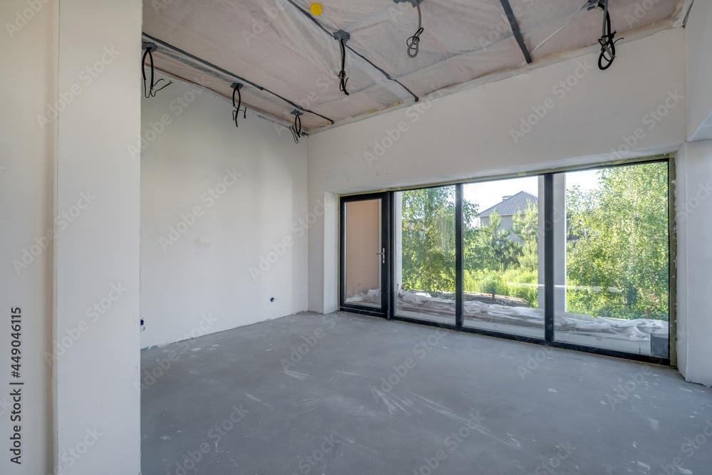 Fototapeta premium Empty unfurnished room with minimal preparatory repairs. interior with white walls and drywall