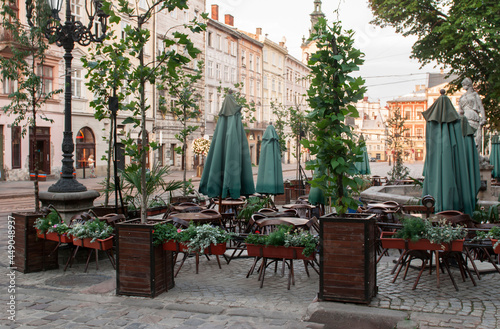 Closed cafe restaurant with wood chairs, stacked upon tables outdoor in Lviv, Ukraine