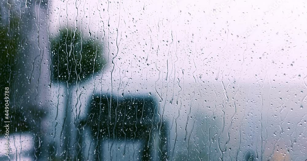 rain drops falling on the window glass at windy, rainy day