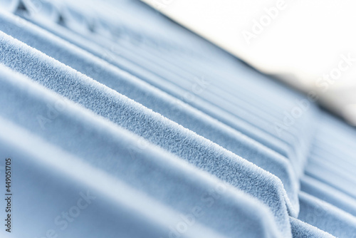 Frost on the roof, corrugated sheet covered with white ice crystals macro view. Winter weather and negative temperatures.