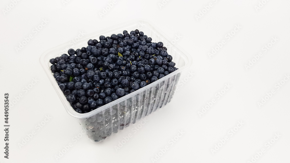 blueberries in a plastic black box insulated on white. sale of summer berries. blueberries in a plastic black box insulated on white. sale of summer berries.