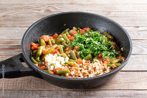 Traditional Caucasian Georgian lobio of green beans with vegetables and tomato in a frying pan. Step by step recipe.