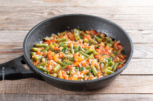 Traditional Caucasian Georgian lobio of green beans with vegetables and tomato in a frying pan. Step by step recipe.