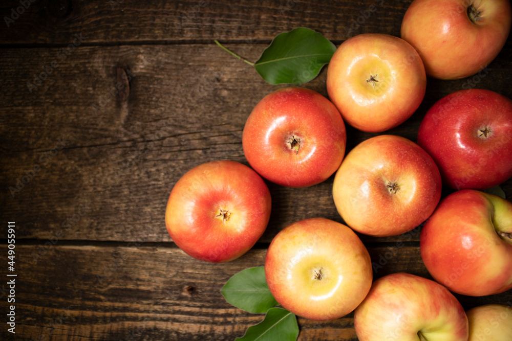 Red and yellow ripe apples lying on a wooden table in the form of a pyramid.Fresh bright fruits and berries on a wooden background. Red and yellow ripe apples lying on a wooden table in the form of a pyramid.Fresh bright fruits and berries on a wooden background.
