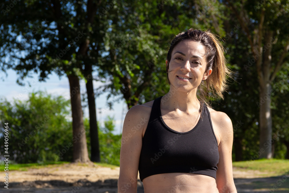Young woman resting and smiling to camera after practicing sport. Healthy lifestyle. Selective focus. Young woman resting and smiling to camera after practicing sport. Healthy lifestyle. Selective focus.