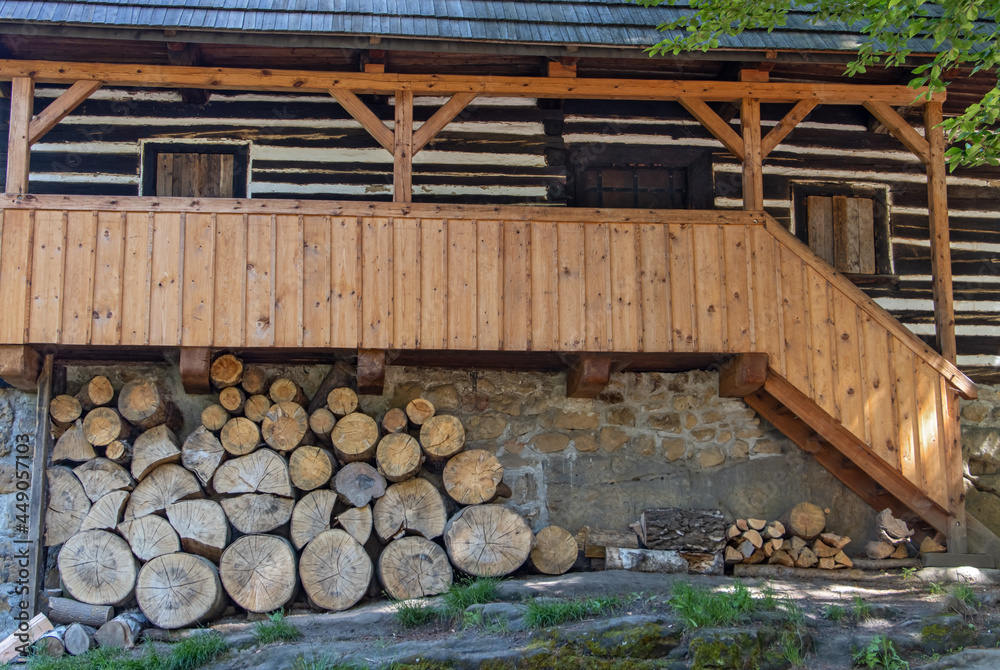 A half-timbered house with a veranda under which there is firewood A half-timbered house with a veranda under which there is firewood