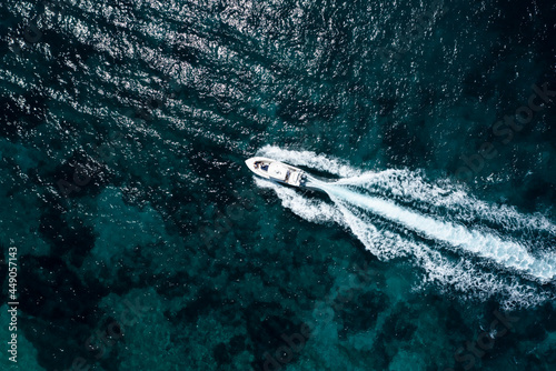 View from above, stunning aerial view of a luxury yacht sailing on a blue water. Costa Smeralda, Sardinia, Italy.