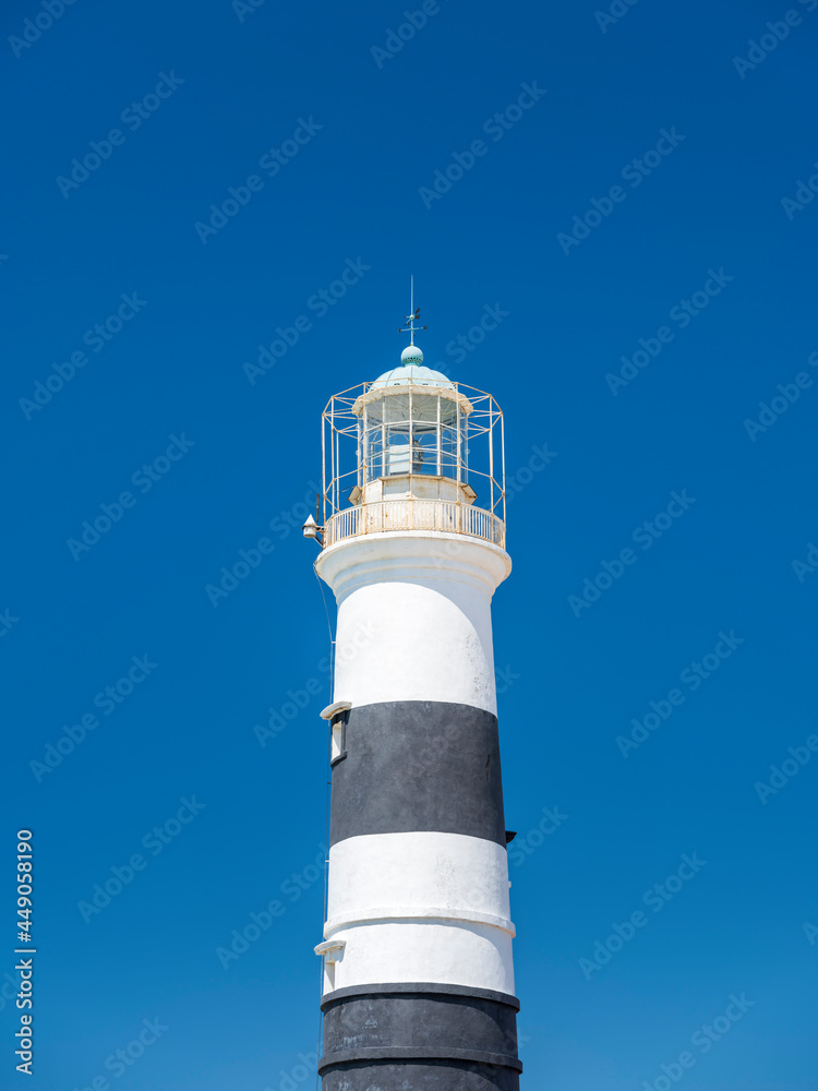 isolated tower of lighthouse on blue sky background in vertical frame with copy space