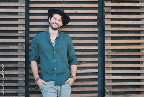 Sexy man model dressed in black hat and in green shirt