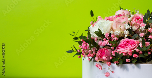 Fototapeta Naklejka Na Ścianę i Meble -  Beautiful pink flowers on a green background in a cardboard box