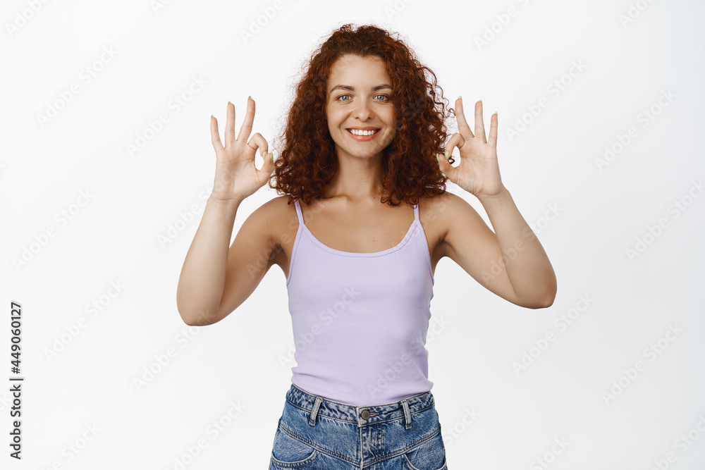 okay. Satisfied redhead girl shows OK approve sign, smiling pleased, recommending, guarantee quality, praise store, standing over white background okay. Satisfied redhead girl shows OK approve sign, smiling pleased, recommending, guarantee quality, praise store, standing over white background