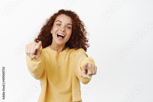 Image of happy laughing girl pointing fingers at camera, smiling joyful, picking you, choosing, inviting to work for company, congratulating, standing over white background