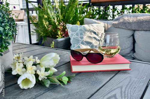 Cozy sheltered patio deck for relaxing with a book and glass of wine on hot days in beautiful lanai with Caribbean or New Orleans decor style.