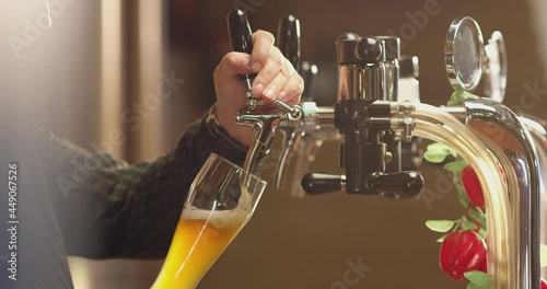 Pouring cold beer into glass. Bartender pouring craft beer in the bar. The hand of a master brewer pour from keg a light draft beer foam . Stout, Light, Unfiltered beer, ready to drink . Slow motion .