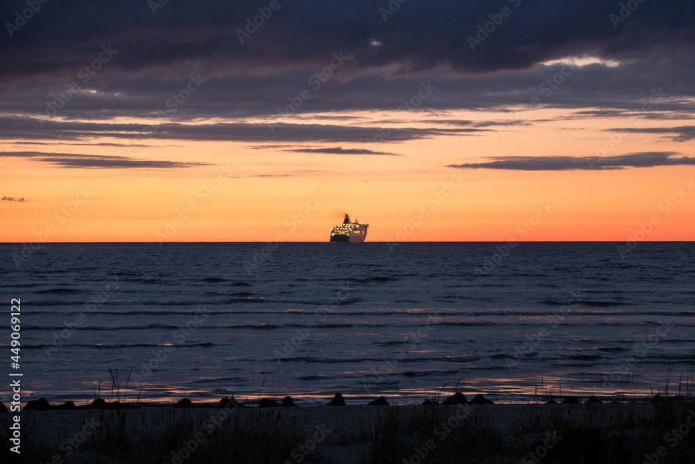 Cruise ship sailing at the horizon on the Baltic Sea after sunset, beautiful dramatic colors