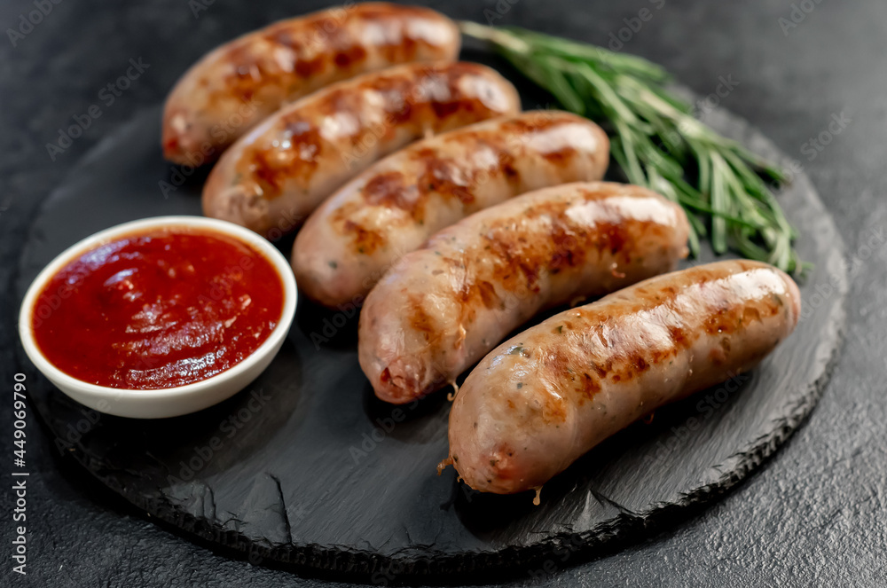 grilled sausages with spices, rosemary on a stone background grilled sausages with spices, rosemary on a stone background