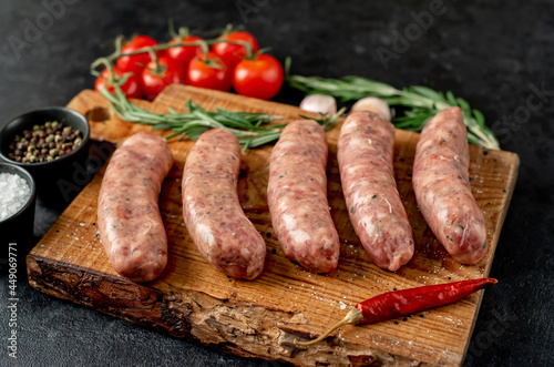 raw sausages for grilling on a stone background