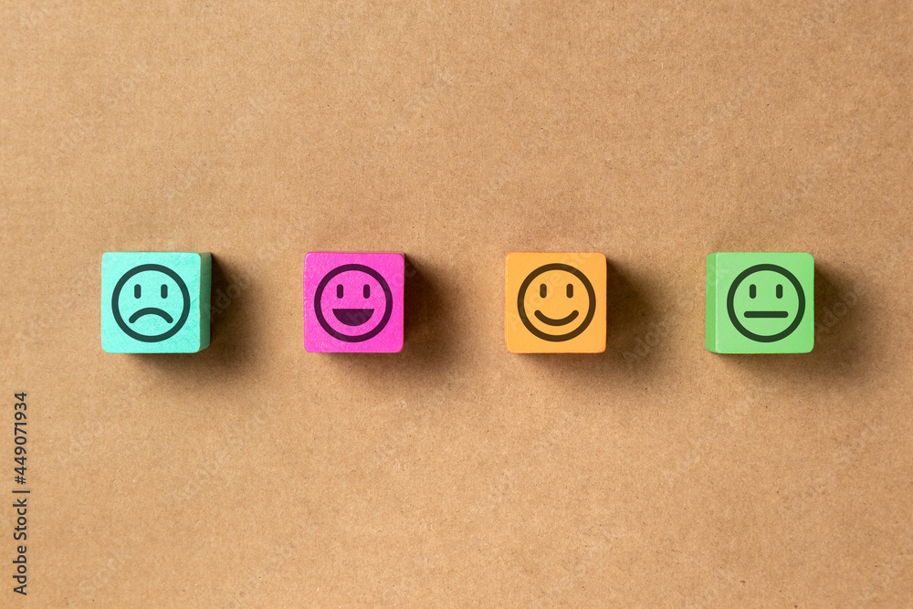 Emoticon faces in colors wooden blocks over brown paper. Service evaluation and satisfaction survey concepts. Angry, neutral, good mood and happy. Copy space. Flat lay photo. Emoticon faces in colors wooden blocks over brown paper. Service evaluation and satisfaction survey concepts. Angry, neutral, good mood and happy. Copy space. Flat lay photo.