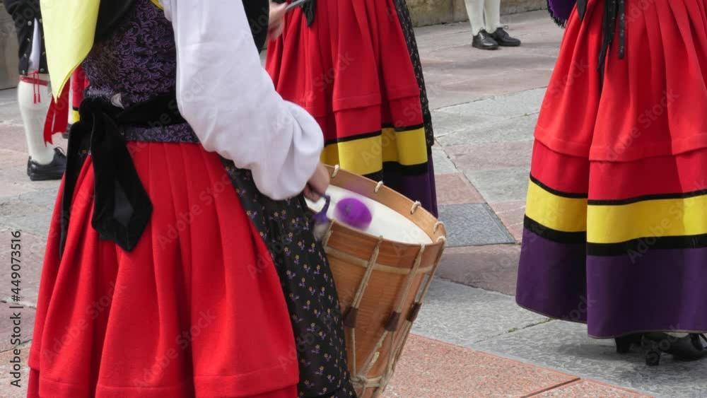 Woman in colorful Asturian costume playing the drum in Oviedo. Asturias