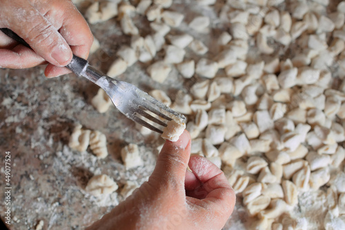 hands making gnocchi pasta with a fork. photo