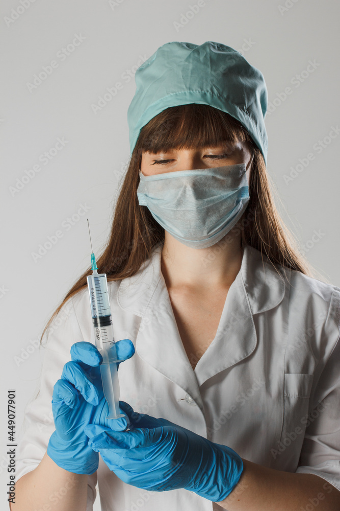 Woman with a medical mask and hands in latex glove shows vaccination concept. Nurse is holding syringe. Protection against coronavirus. Woman doctor wearing medical mask encourages vaccination Woman with a medical mask and hands in latex glove shows vaccination concept. Nurse is holding syringe. Protection against coronavirus. Woman doctor wearing medical mask encourages vaccination