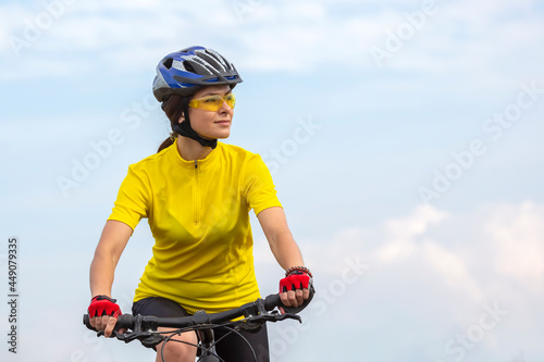 Beautiful woman cyclist with a bicycle on the nature. Healthy lifestyle and sport. Leisure and hobbies