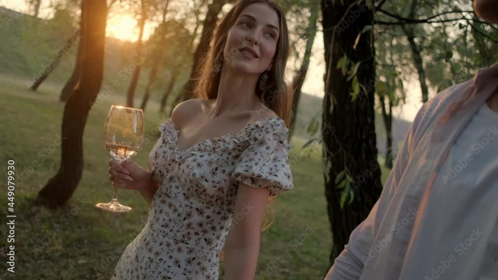 a couple in love on a walk with glasses of wine a couple in love on a walk with glasses of wine