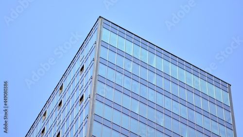 Futuristic facade of a modern office building clad in glass. Glass cladding panels and windows of modern building. An office building with geometry and perspective.