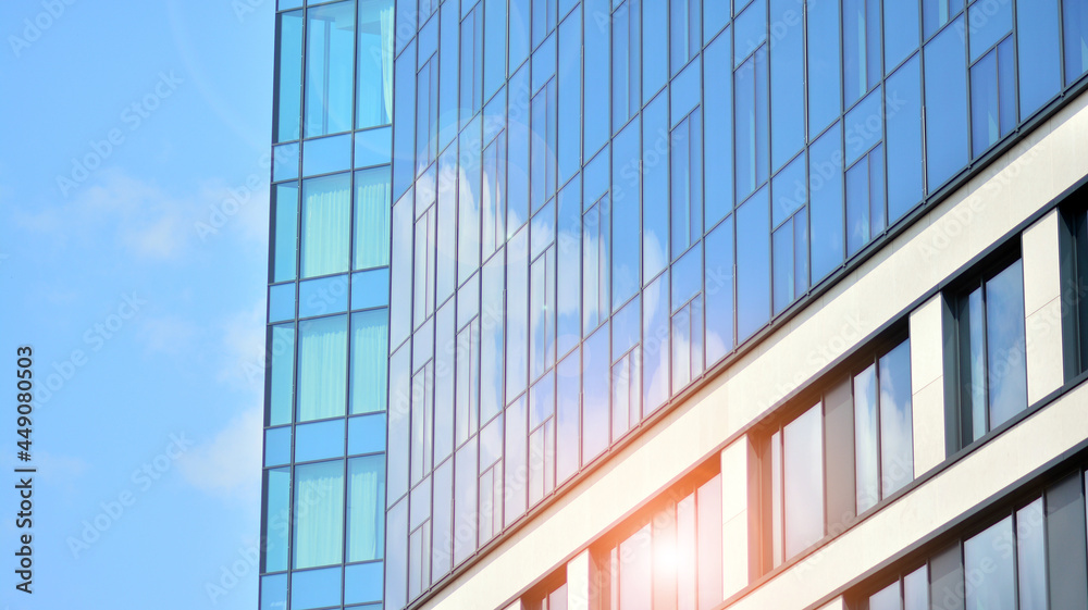 Futuristic facade of a modern office building clad in glass. Glass cladding panels and windows of modern building. An office building with geometry and perspective. Futuristic facade of a modern office building clad in glass. Glass cladding panels and windows of modern building. An office building with geometry and perspective.