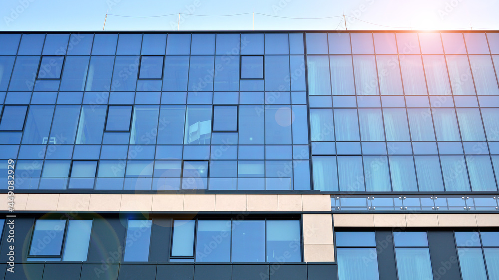 Futuristic facade of a modern office building clad in glass. Glass cladding panels and windows of modern building. An office building with geometry and perspective. Futuristic facade of a modern office building clad in glass. Glass cladding panels and windows of modern building. An office building with geometry and perspective.