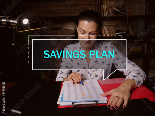  SAVINGS PLAN text in footnote block. Bookkeeping clerk checking financial report An employer-provided tax-deferred account typically used to save for retirement photo